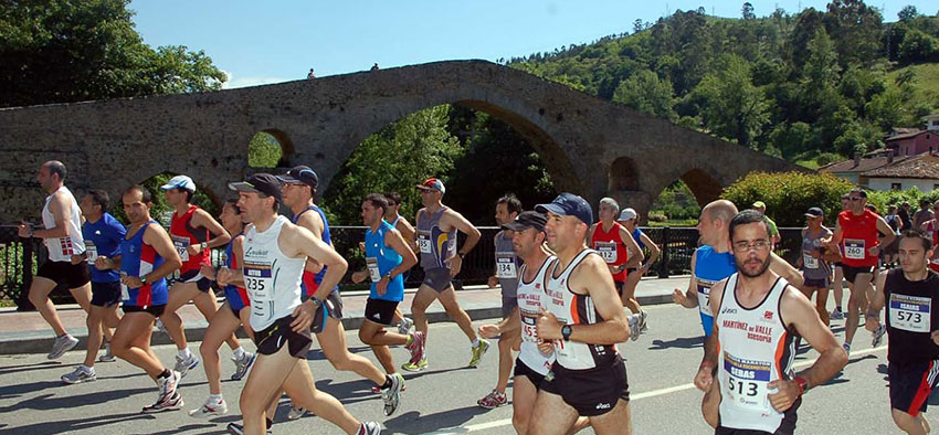 atletas pasando por delante del Puente de Cangas de Onís